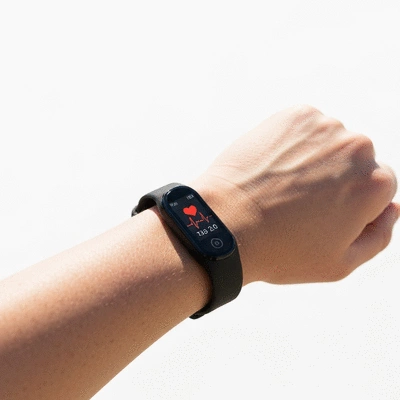 Close-up of a person's wrist wearing a sleek fitness tracker, showing heart rate data on a screen, clean image, no text, no words, no typography, no labels